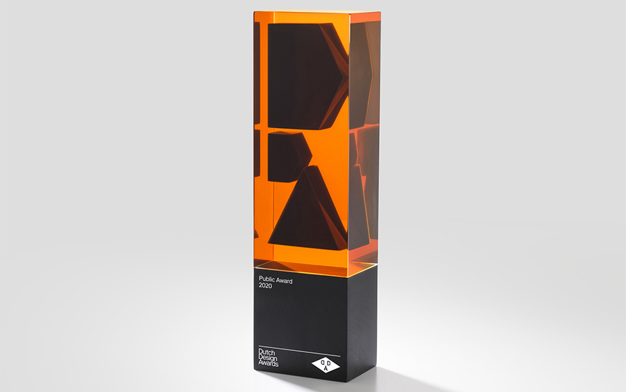 Trophée Dutch Design Awards en résine orange translucide avec trois formes noires et un socle noir
